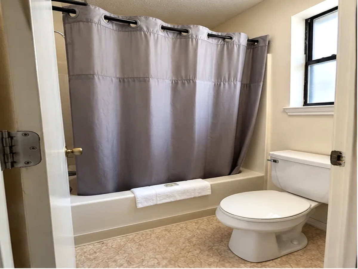 Guest bathroom with tub, shower and toilet at Bob's Lake Country Motel